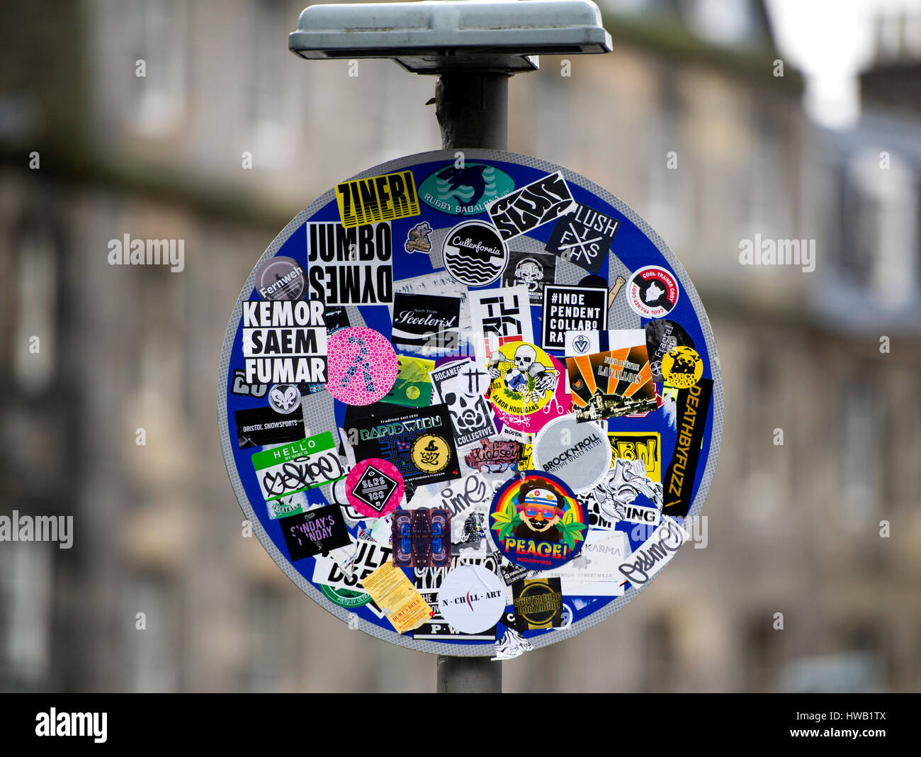 Werbe-Flyer und Aufkleber verdeckt die Verkehrszeichen Richtung bedeckt ein Straßenschild in Edinburgh. Stockfoto