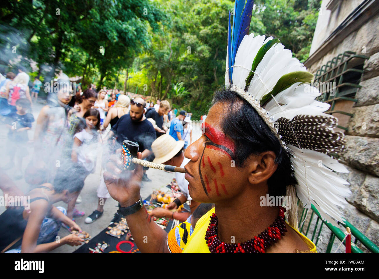 Traditionelle brasilianische Inder mit bemaltem Gesicht seine Pfeife rauchen im Parque Laje in der comemoration des Tages des Indischen, Rio de Janeiro, Brasilien Stockfoto