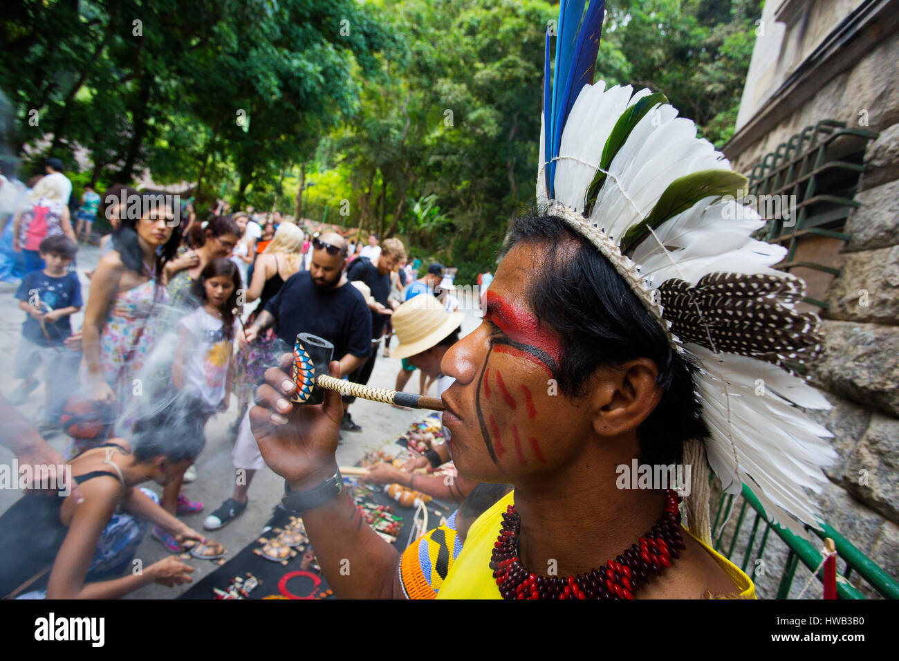 Traditionelle brasilianische Inder mit bemaltem Gesicht seine Pfeife rauchen im Parque Laje in der comemoration des Tages des Indischen, Rio de Janeiro, Brasilien Stockfoto