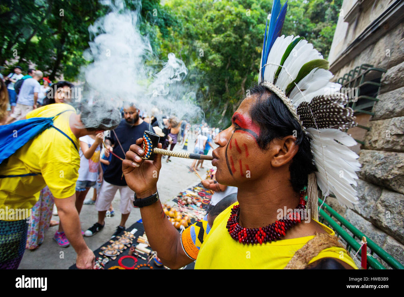 Traditionelle brasilianische Inder mit bemaltem Gesicht seine Pfeife rauchen im Parque Laje in der comemoration des Tages des Indischen, Rio de Janeiro, Brasilien Stockfoto