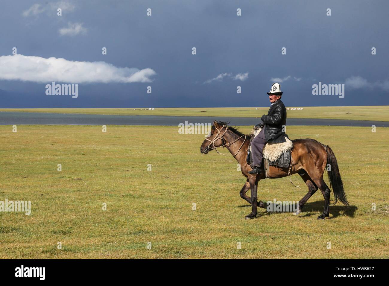 Kirgisistan, Naryn Provinz, Stadtrundfahrt und Mountain trek, Kirgisen Reiten mit seiner traditionellen kalpak Stockfoto