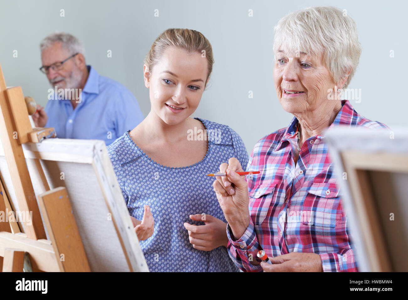 Senioren besuchen Malkurs mit Lehrer Stockfoto