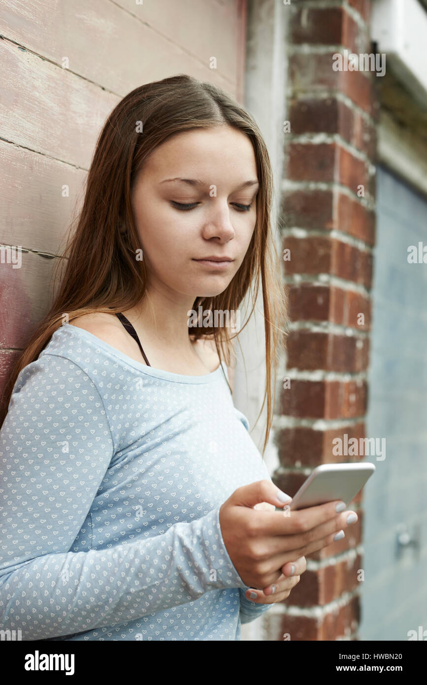 Teenager-Mädchen SMS auf Handy im städtischen Umfeld Stockfoto