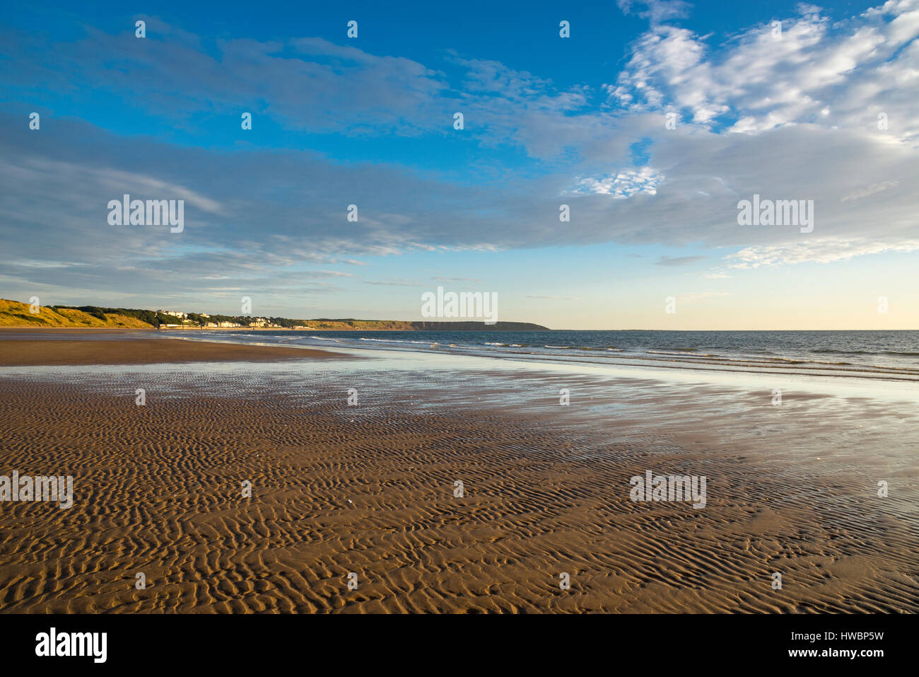 Wellen im Sand bei Ebbe am Strand von Filey Bay, North Yorkshire, England. Ein schöner sonniger Morgen. Stockfoto