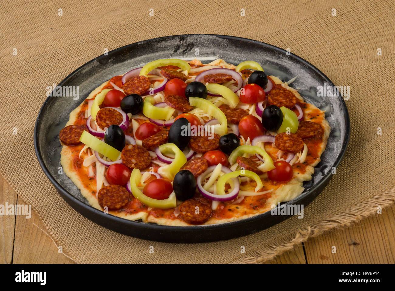 Rohe rustikale Pizza in Pfanne vor dem Backen Stockfoto