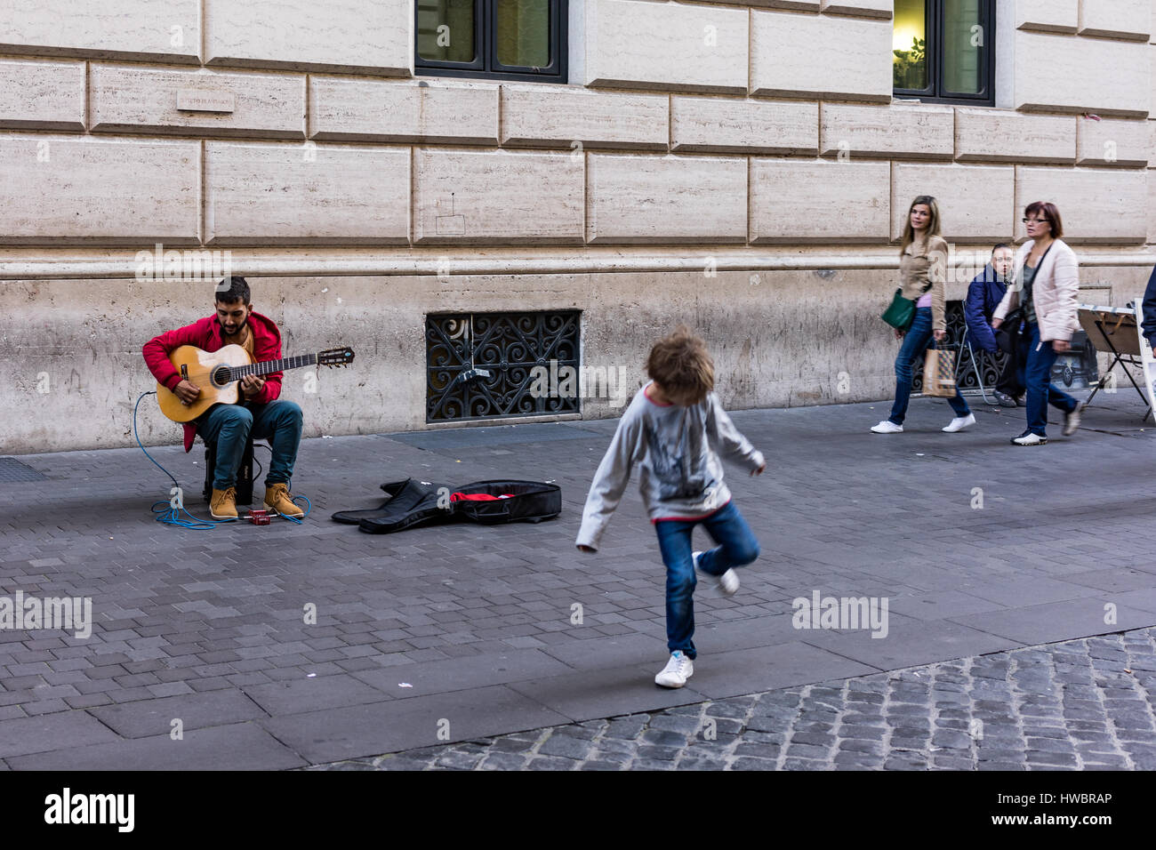Gitarrist macht ein Kind Tanz Stockfoto