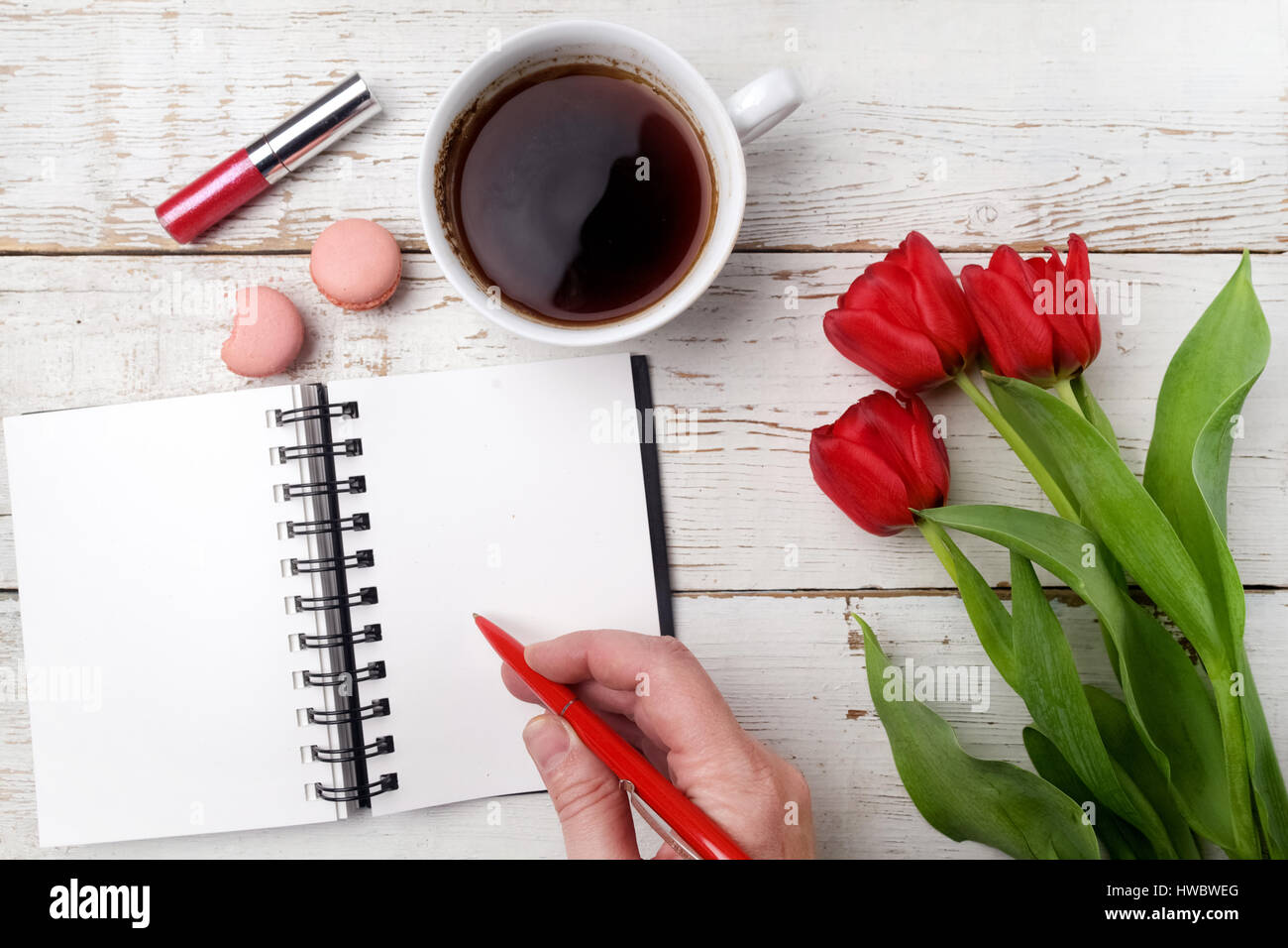 Rote Tulpen, Kaffeetasse und Notebook über weißen Holztisch. Flach zu legen Stockfoto