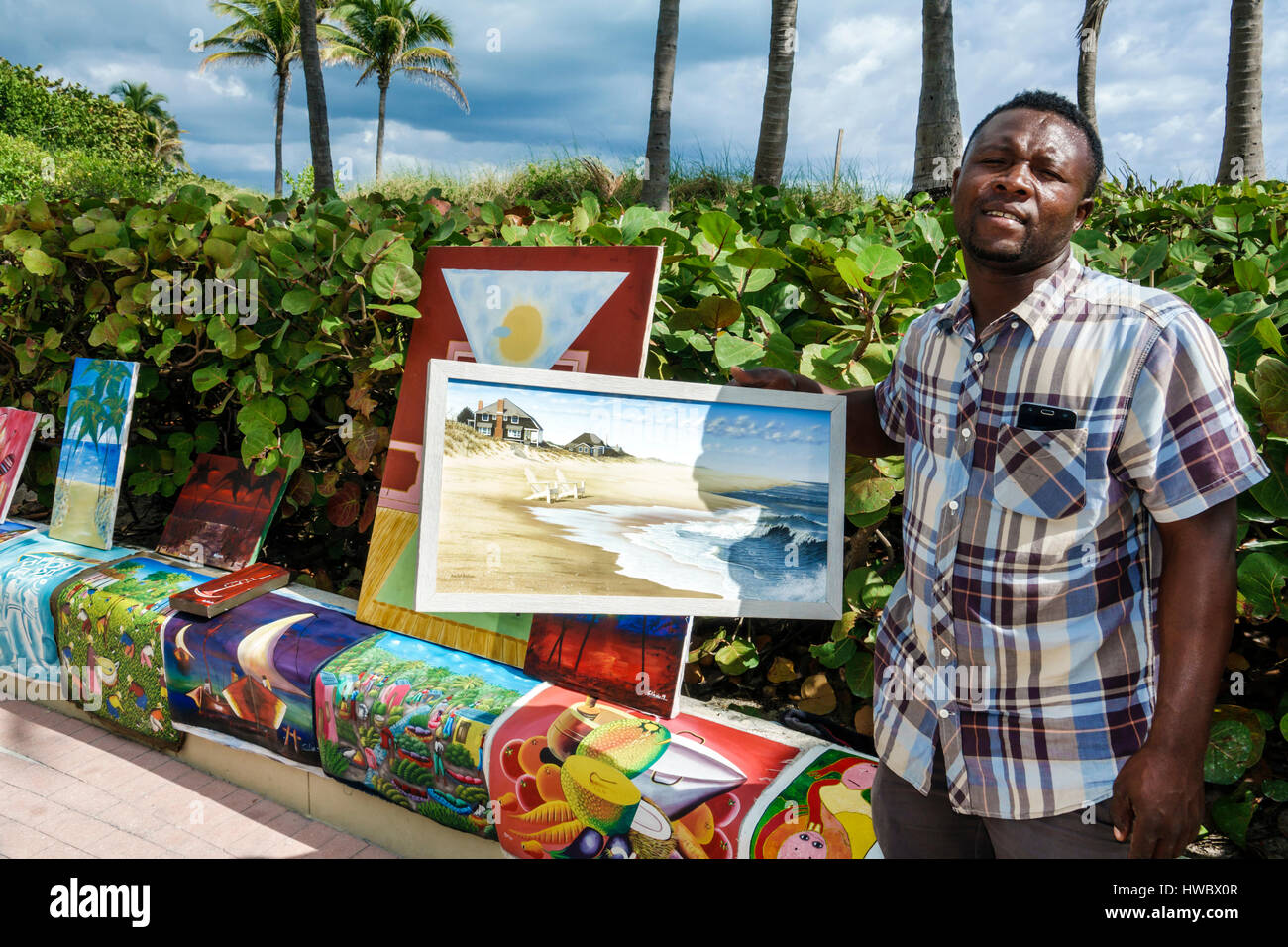 Miami Beach Florida, South Beach Boardwalk, Beachwalk, schwarzer Haitianer, Mann Männer männlich, Künstler, Bürgersteig Verkäufer, Gemälde, Volkskunst, Display Sale FL170205014 Stockfoto