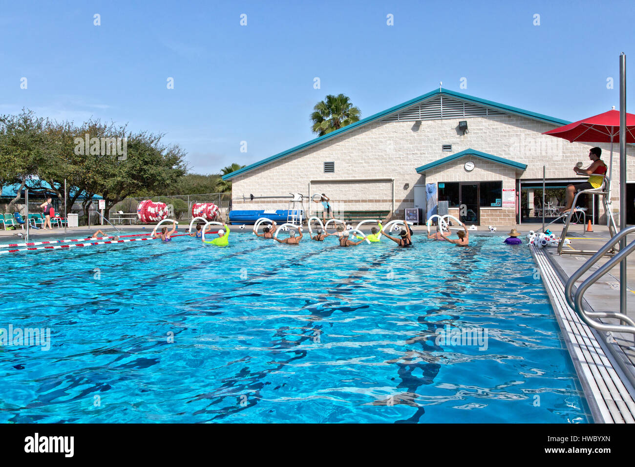 Gruppe von Frauen (verschiedenen Alters) Teilnahme an Wasser-Aerobic-Kurs, Ausbilder demonstriert, mit "Wasser Nudel" Rettungsschwimmer besuchen, Stockfoto