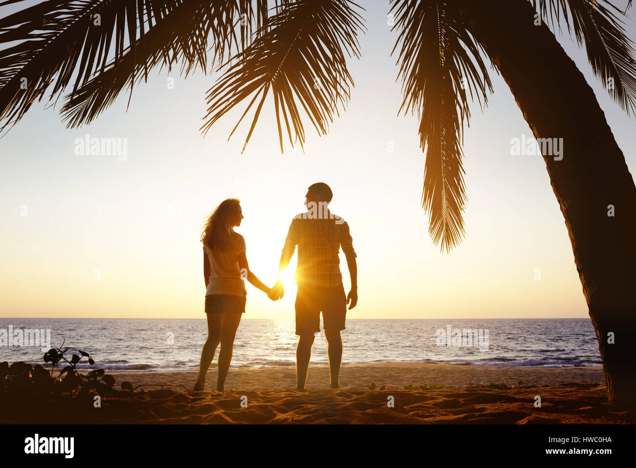 Glückliches Paar Sonnenuntergang Strand unter Palmen Stockfoto