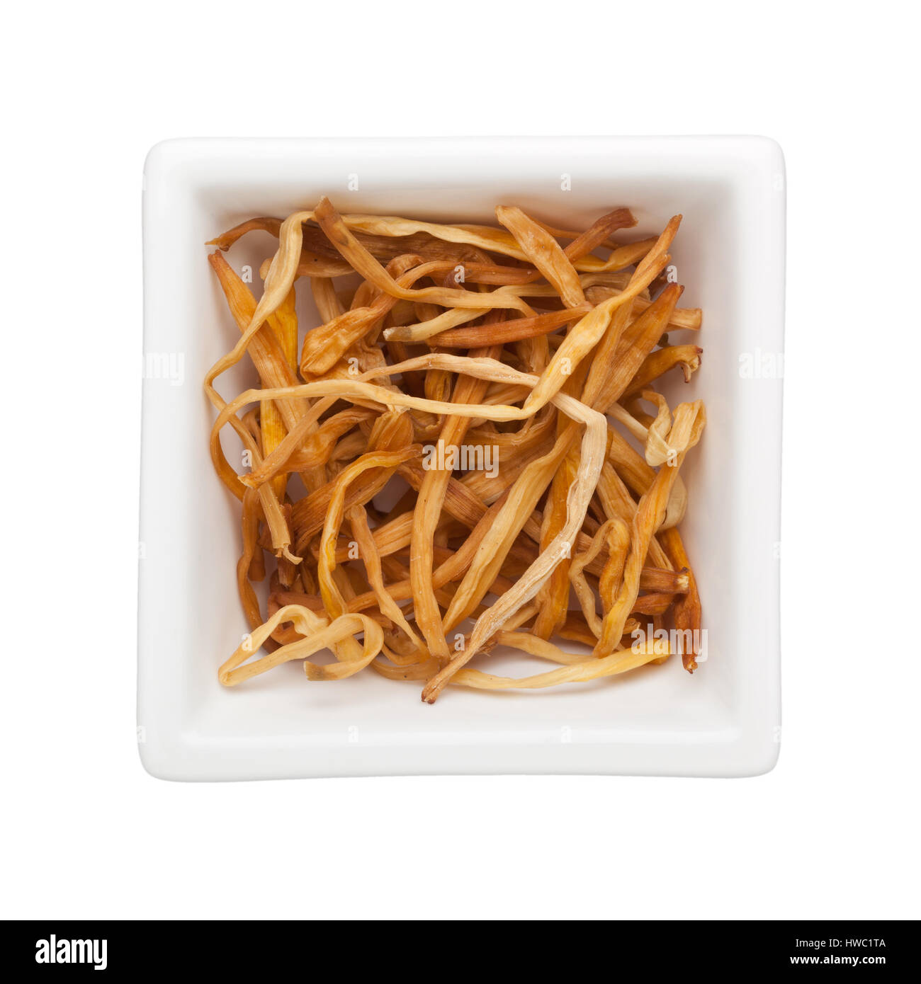Traditionelle chinesische Medizin - Jin Zhen (getrocknete Taglilien) in eine quadratische Schale isoliert auf weißem Hintergrund Stockfoto
