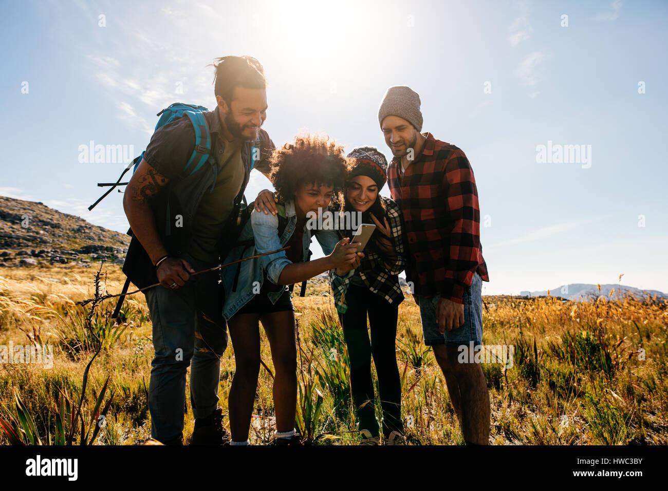 Afrikanische Frau mit Freunden im Landschaft zu fotografieren. Gruppe junger Menschen wandern in der Natur und fotografieren. Stockfoto