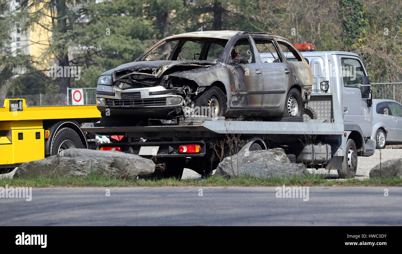 Feuerschaden auf Autowrack auf einen Flachbett Abschleppwagen am Tatort geladen Stockfoto