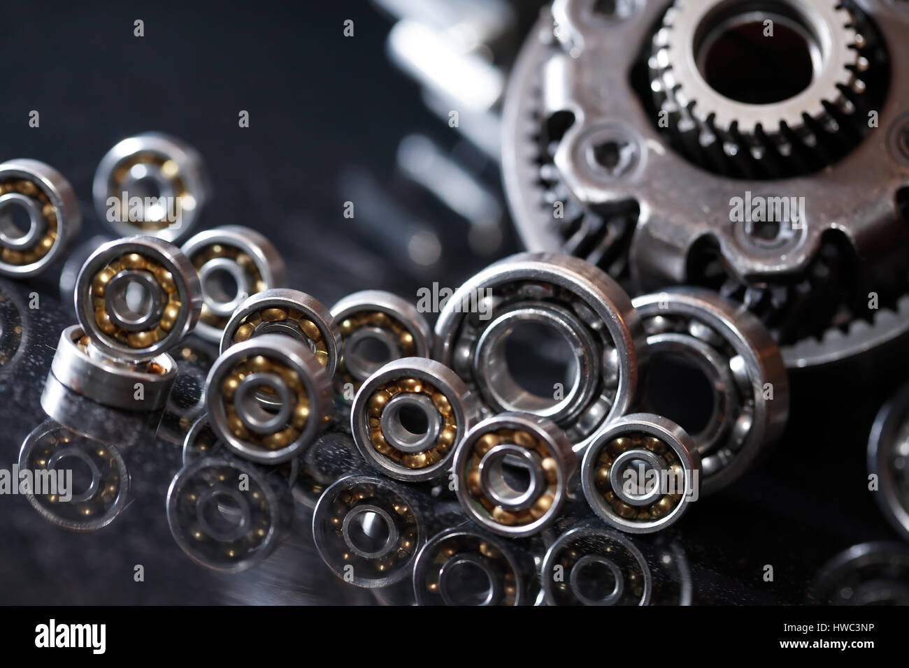 Maschinenkonzept. Reihe von verschiedenen Zahnräder und Kugellager auf dunklem Hintergrund Stockfoto