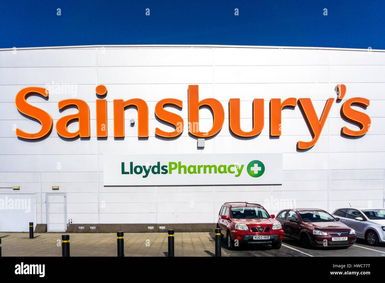 Ein Zeichen für Sainsbury und Lloyds Pharmacy an der Seite einer großen Sainsbury supermarked bei Bell Green in Südlondon. Stockfoto