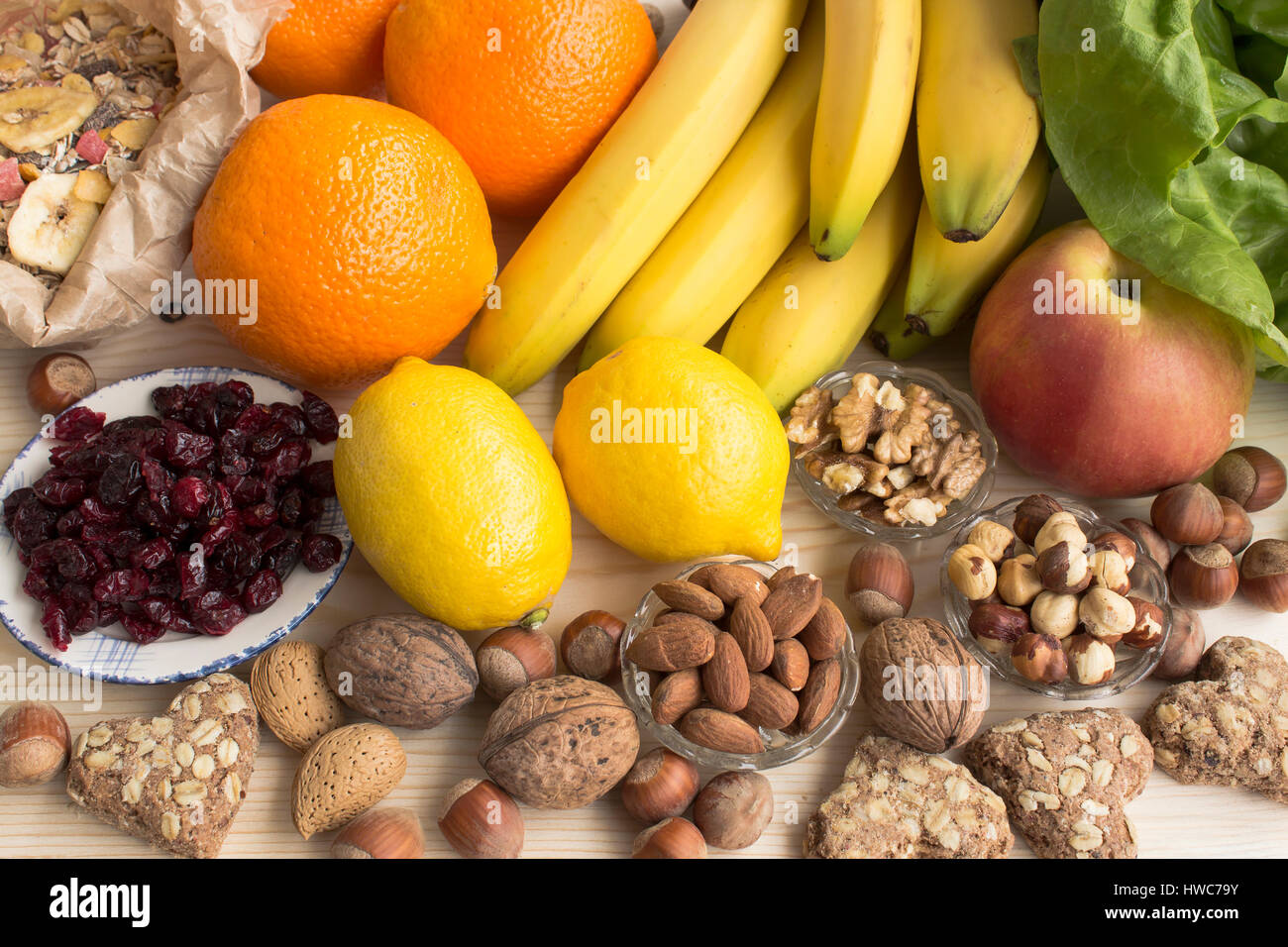 Verschiedene gesunde Ernährung, tropischen Früchten, Nüssen, Müsli, Vollkorn Kekse, Preiselbeeren. Stockfoto
