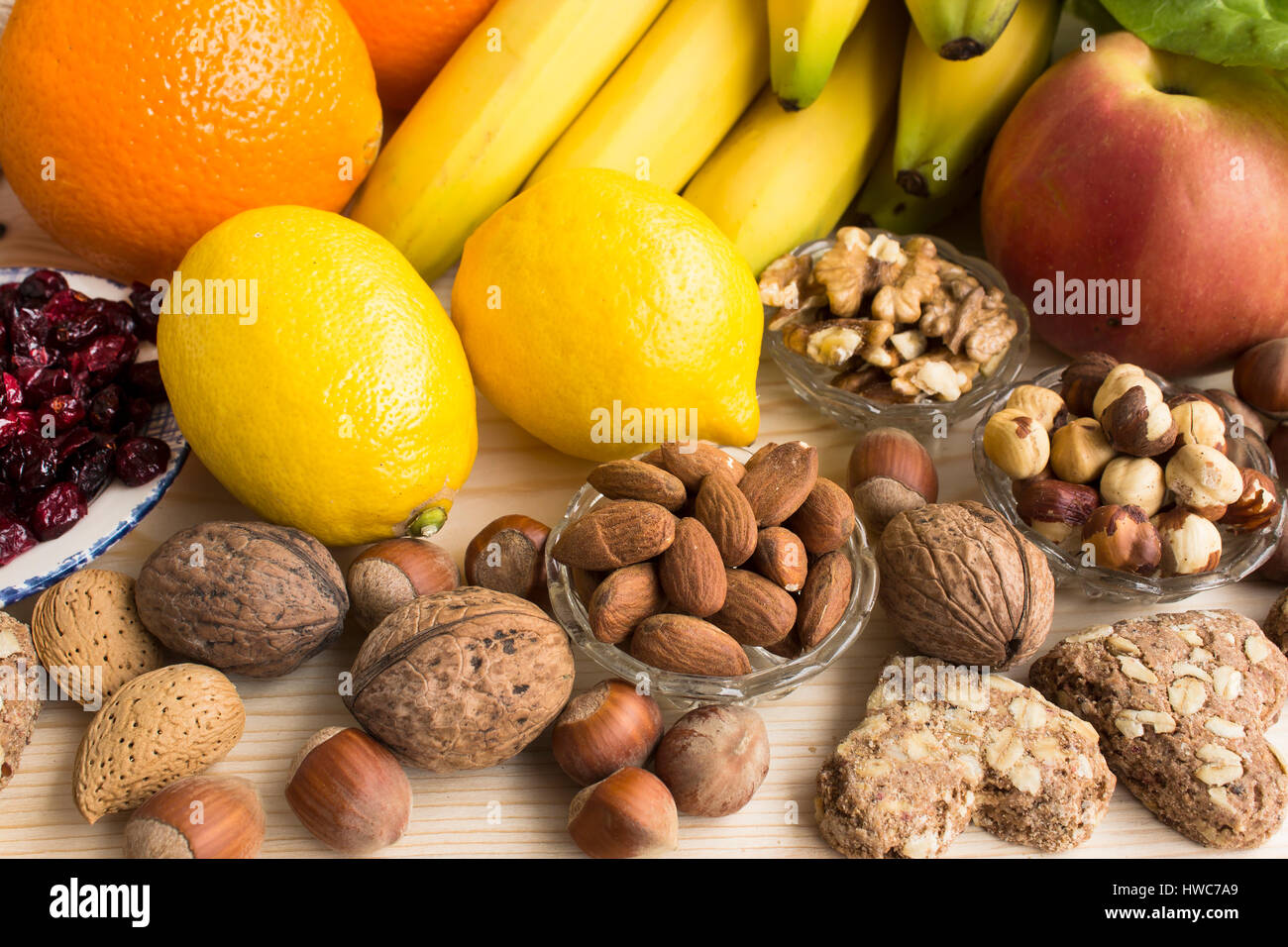 Verschiedene gesunde Ernährung, tropischen Früchten, Nüssen, Vollkorn Kekse, Apfel, Preiselbeeren. Stockfoto