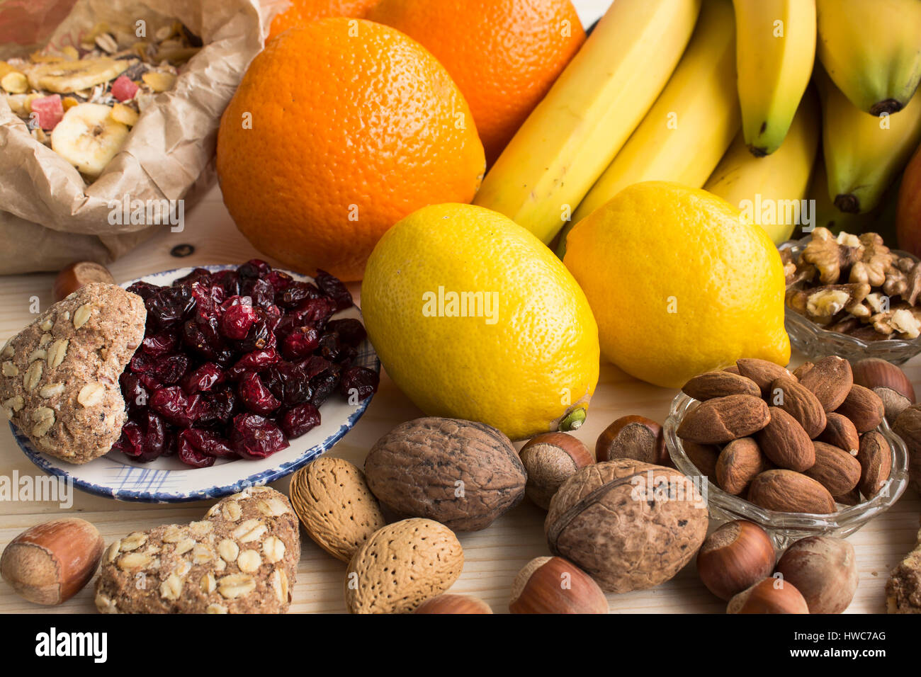 Verschiedene gesunde Ernährung, tropischen Früchten, Nüssen, Müsli, Vollkorn Kekse, Preiselbeeren. Stockfoto