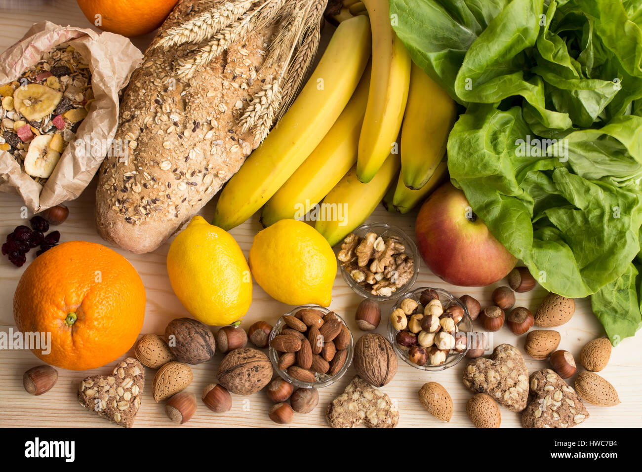 Verschiedene gesunde Ernährung, tropischen Früchten, Nüssen, Müsli, Vollkornbrot und Kekse, Kopfsalat, Apple. Stockfoto