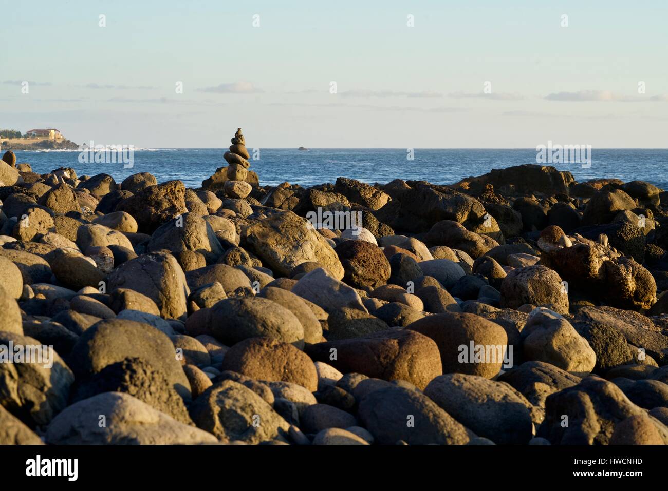 kleine Steinfigur an einem Stein Strand des Ozeans in der Sonne Stockfoto
