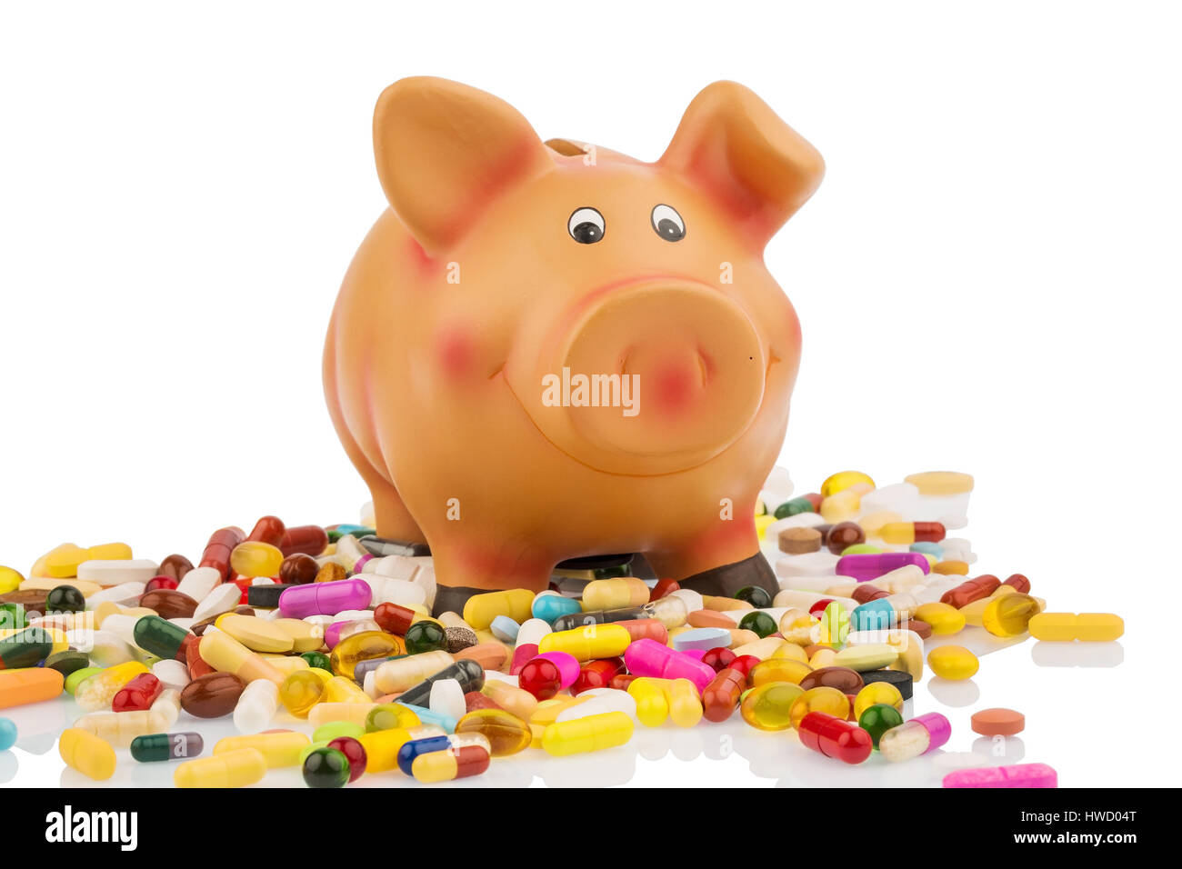 Tablets liegen neben ein lustiges Schwein. Symbolische Foto für Kosten in der Medizin und Pharmaindustrie, Tabletten Stück Neben Einem Sparschwein. Symbolfo Stockfoto