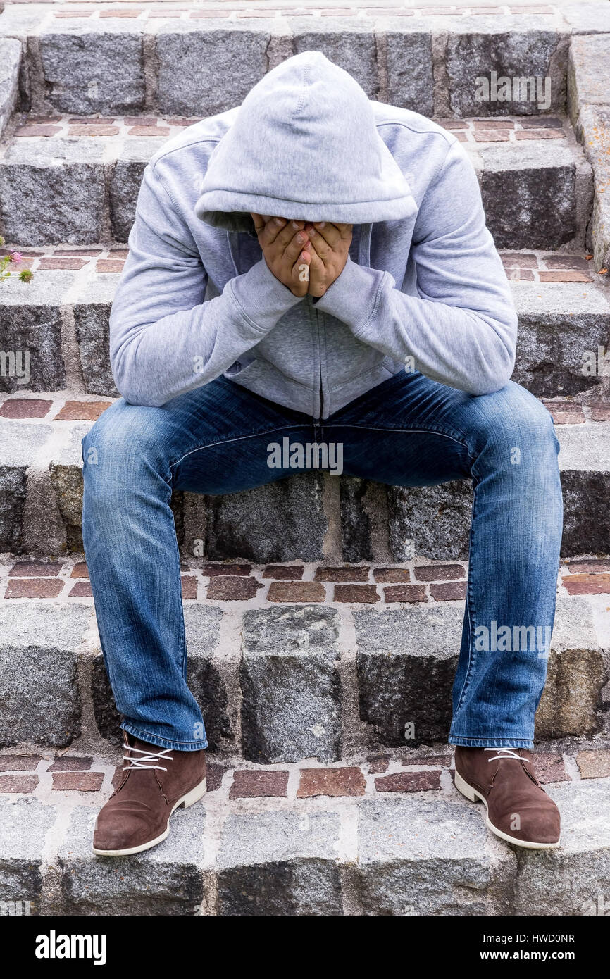 Ein Mann sitzt einsam auf Schritte, Ein Mann Sitzt Einsam Auf Stufen Stockfoto