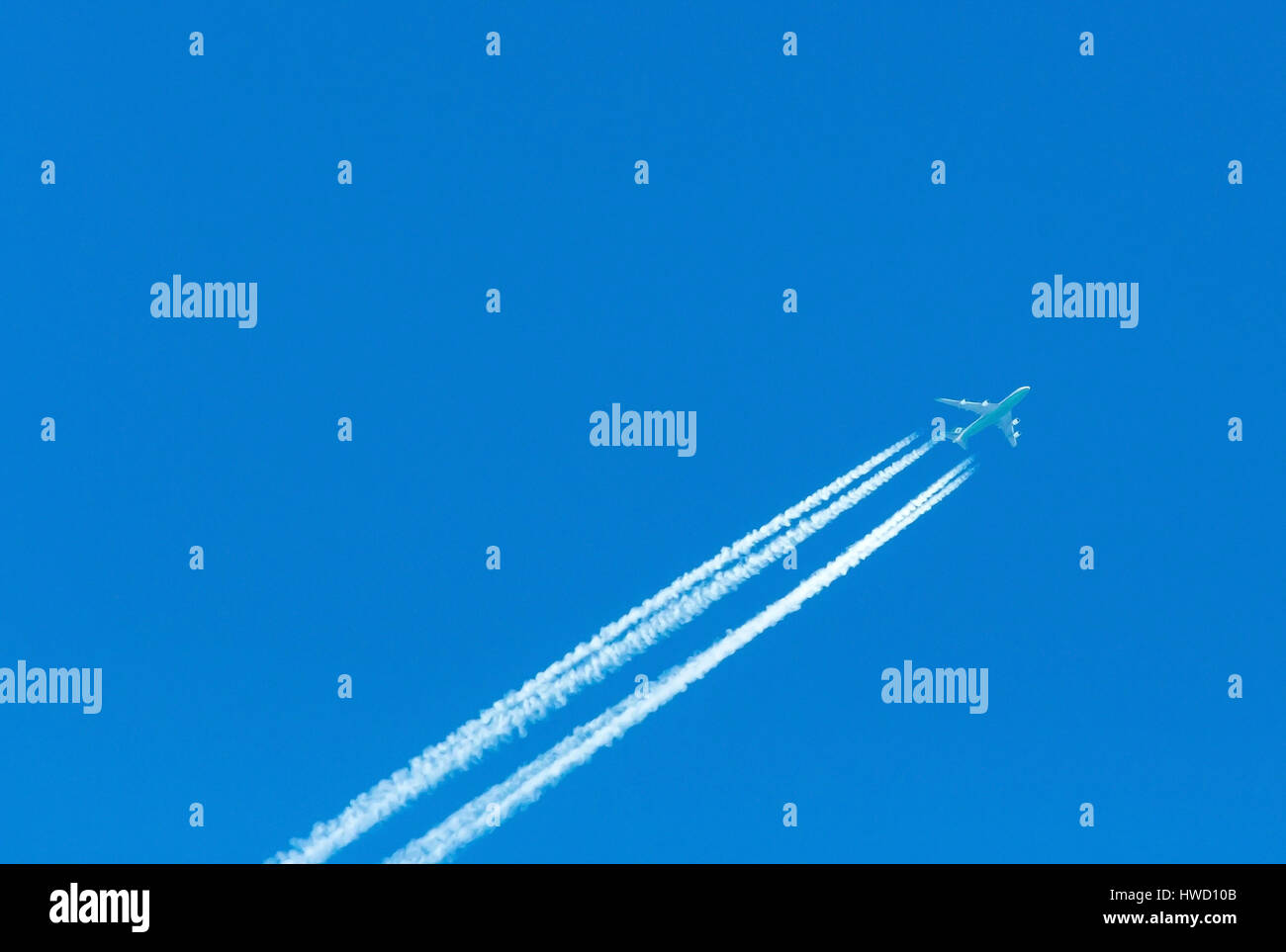 Ein Flugzeug mit Kondensation Trail in den blauen Himmel, Ein Flugzeug Mit Kondensstreifen am Blauen Himmel Stockfoto