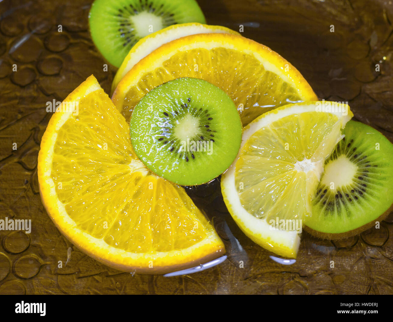 Die in Scheiben geschnittenen Kiwi Zitronen Orangen im Wasser hautnah Stockfoto