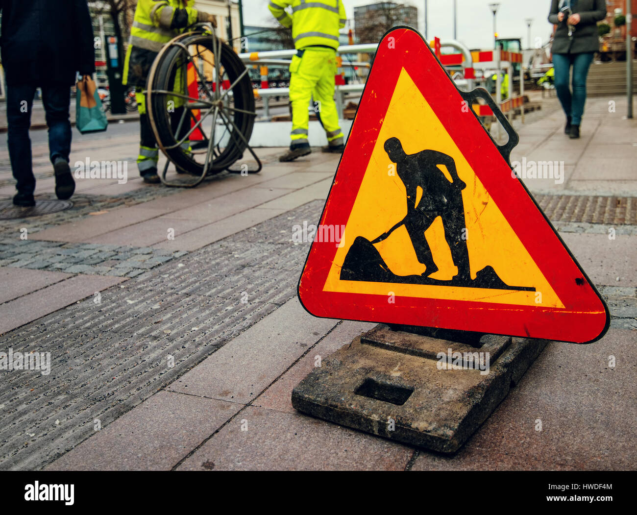 Straßenarbeiten anmelden Stadtstraße, Arbeiter und Passanten im Hintergrund Stockfoto