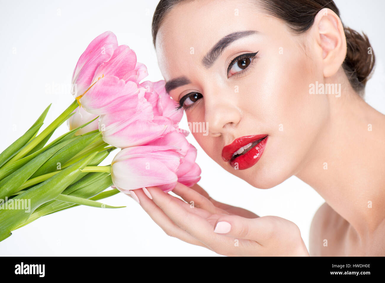 Portrait der schönen Frau berühren Knospen rosa Tulpen Stockfoto