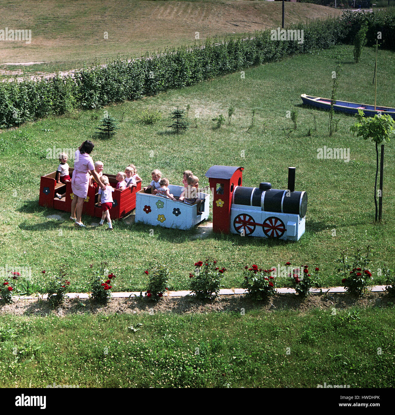 Limbach-Oberfrohna, DDR, Kinder spielen mit ihrer Erzieherin im Garten der Kindertagesstätte Stockfoto