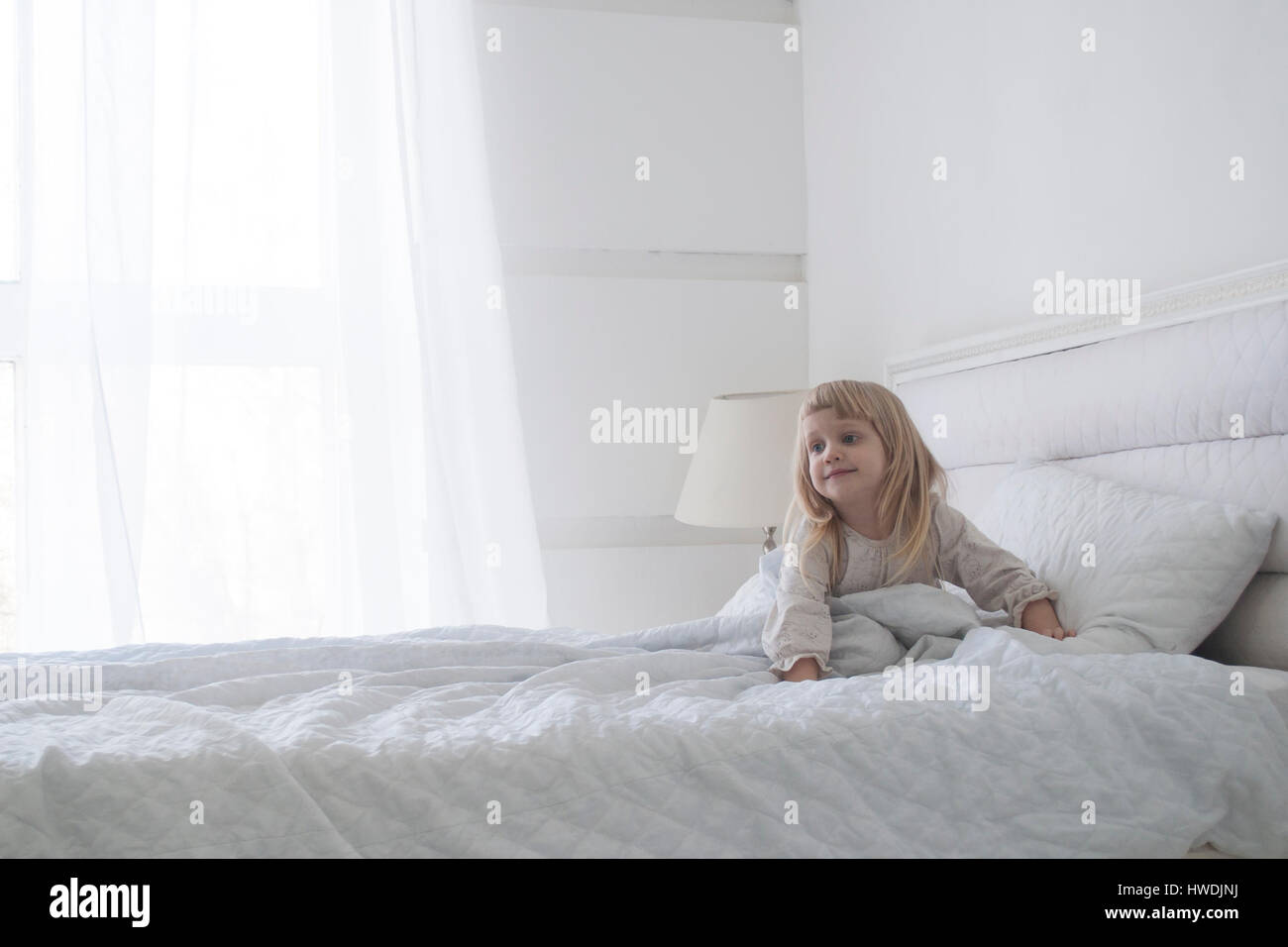 Kleines Mädchen bekommt morgens mit Lächeln, weiße Konzept Stockfoto
