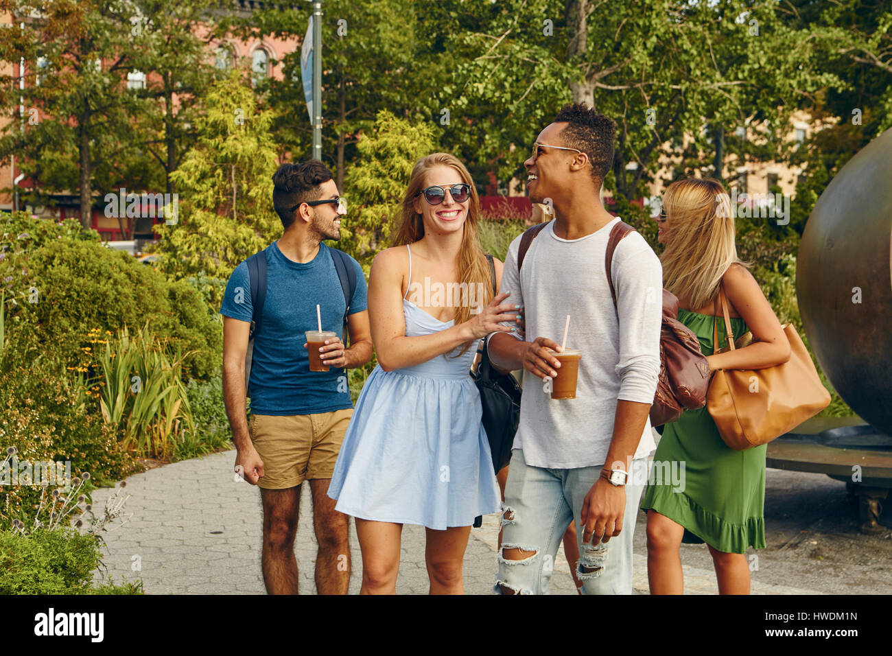 Fünf Erwachsene Freunde, die zusammen im Park spazieren Stockfoto
