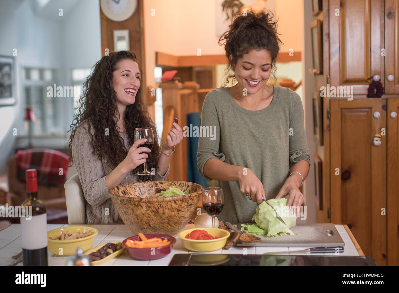 Zwei Freundinnen bereitet Salat am Küchentisch Stockfoto