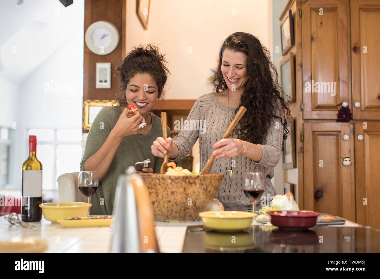 Zwei Freundinnen, die Vorbereitung und das Essen Salat am Küchentisch Stockfoto