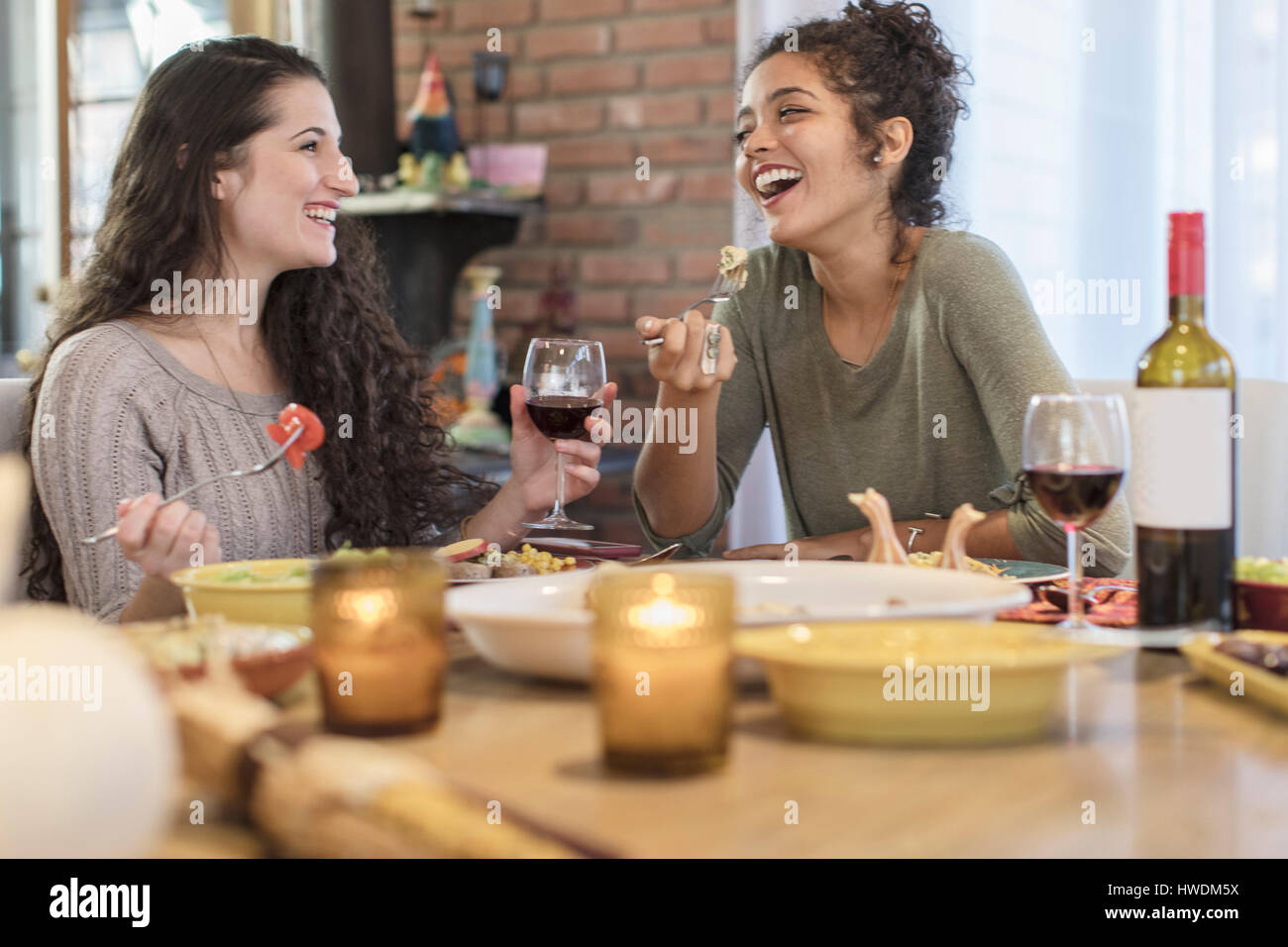 Zwei junge Frauen Freunde Essen am Küchentisch Stockfoto