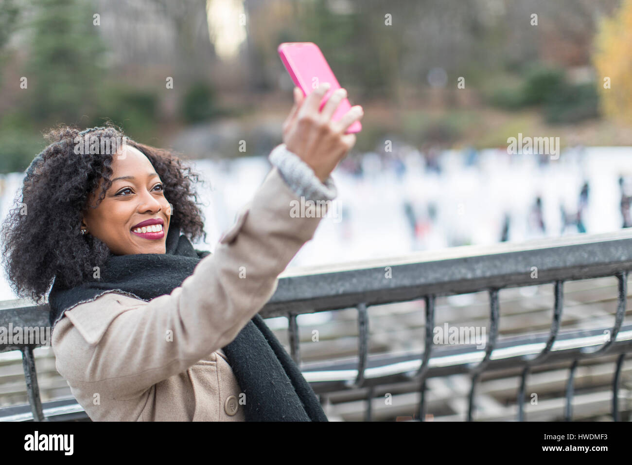 Junge Frau, die die Smartphone Selfie auf Stadt-Balkon Stockfoto