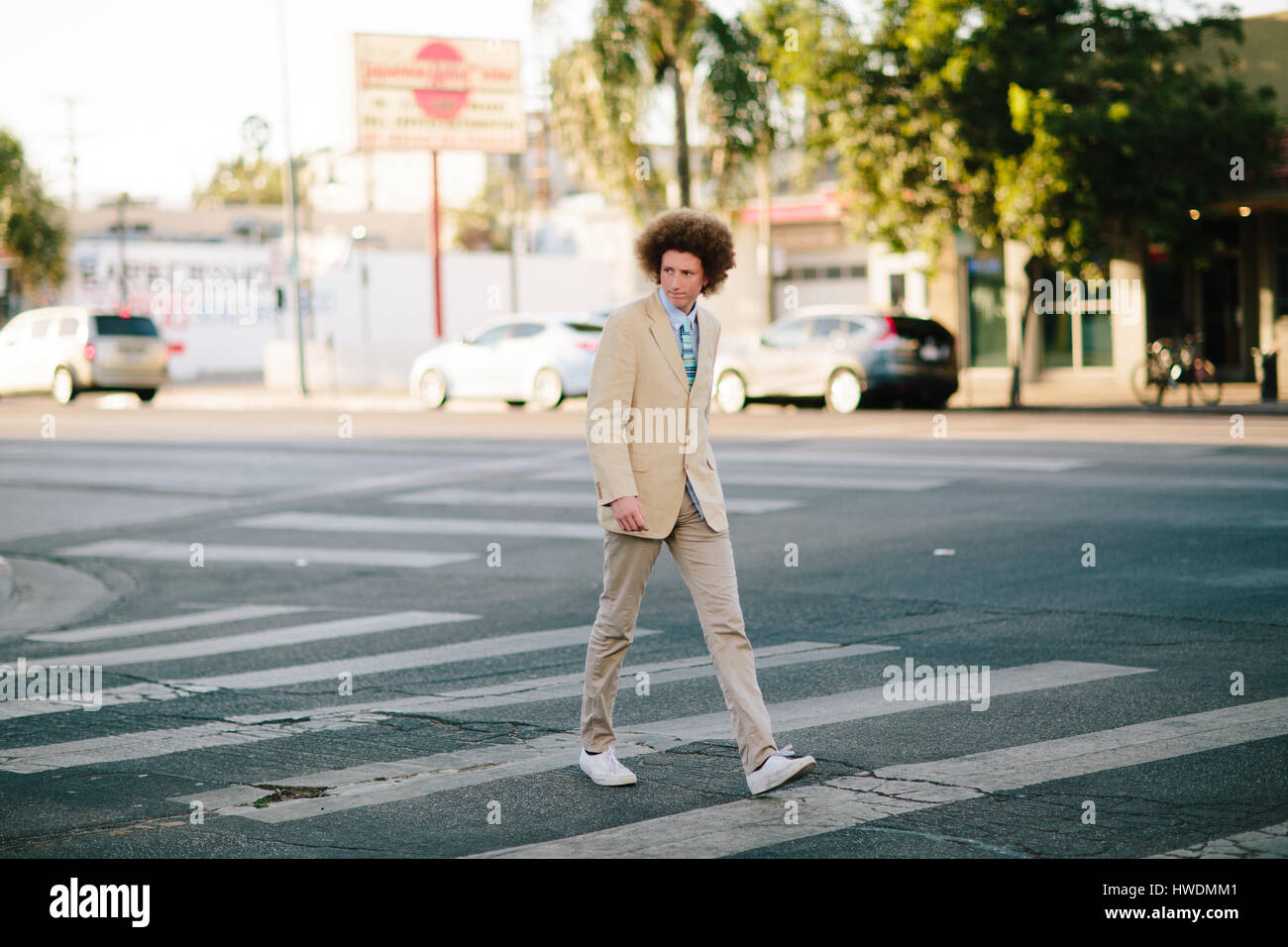 Teenager mit roten Afro-Haar, Anzug, am Fußgängerüberweg Stockfoto