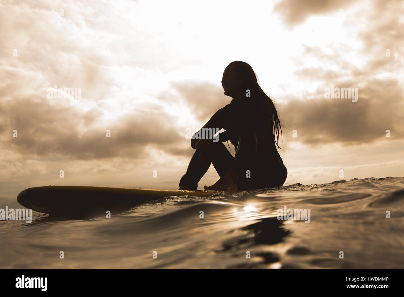 Junge Frau im Meer, sitzen auf Surfbrett Stockfoto