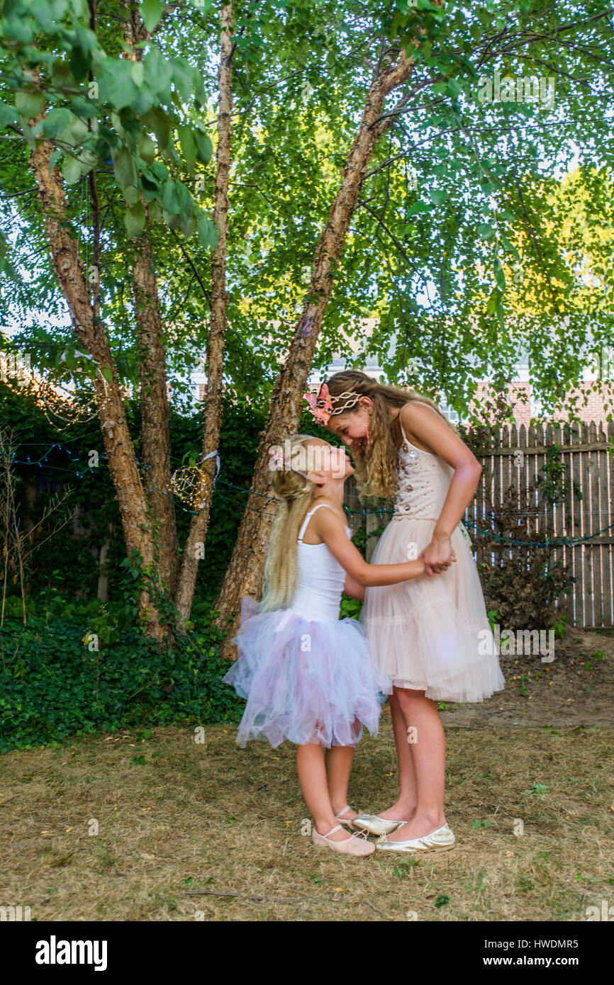 Zwei junge Mädchen gekleidet wie Feen, Hand in Hand, von Angesicht zu Angesicht Stockfoto
