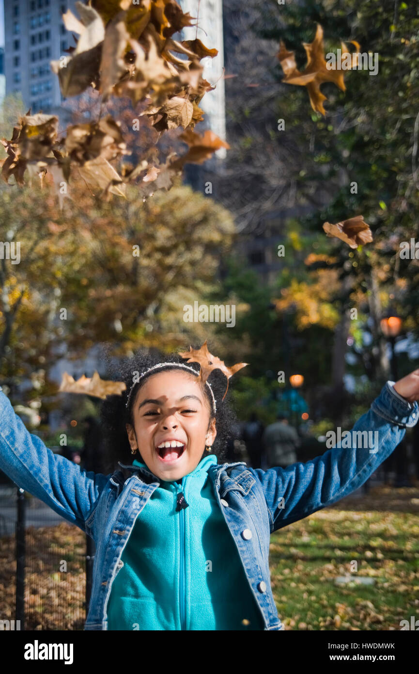 Mädchen werfen Herbst verlässt lächelnd Stockfoto