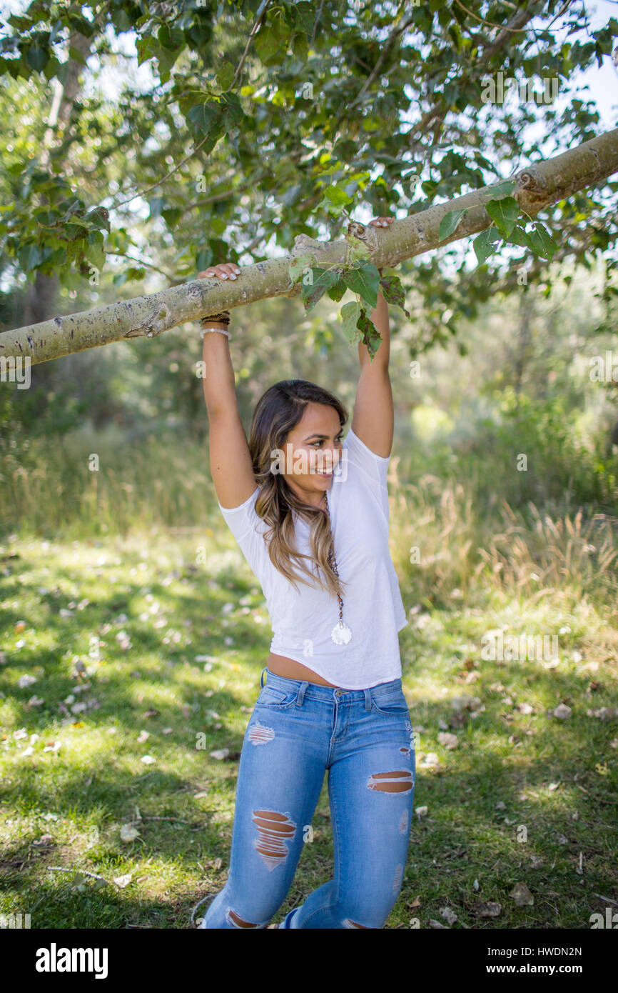 Teenager-Mädchen schwingen von Ast im Wald Stockfoto