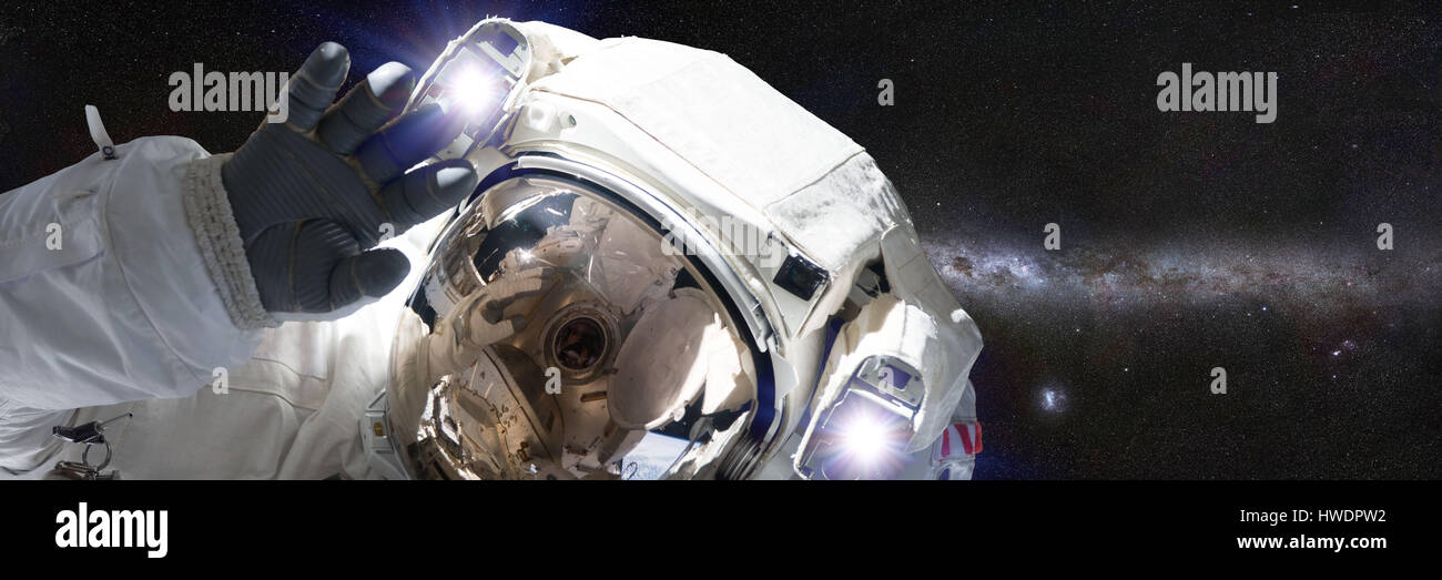 Astronaut vor Milchstraße winken in die Kamera (Banner-Format 3 x 1) Stockfoto