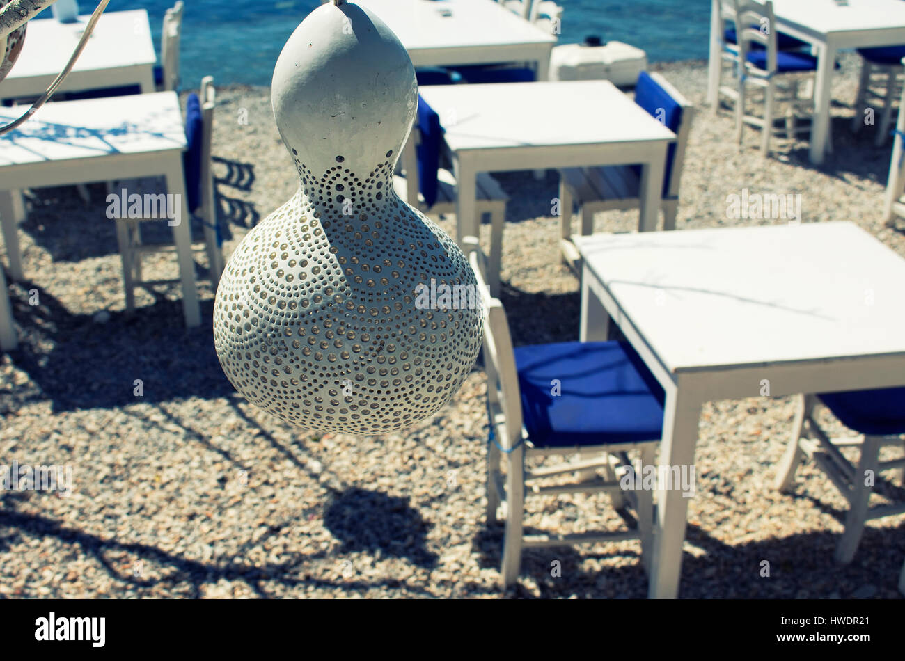 Handgefertigte Lampe hergestellt aus Wasser Kürbis (Kalebasse) an der Küste von Bodrum Stadt in der Türkei. Tische am Strand sind im Hintergrund. Diese Beleuchtung ist comm Stockfoto