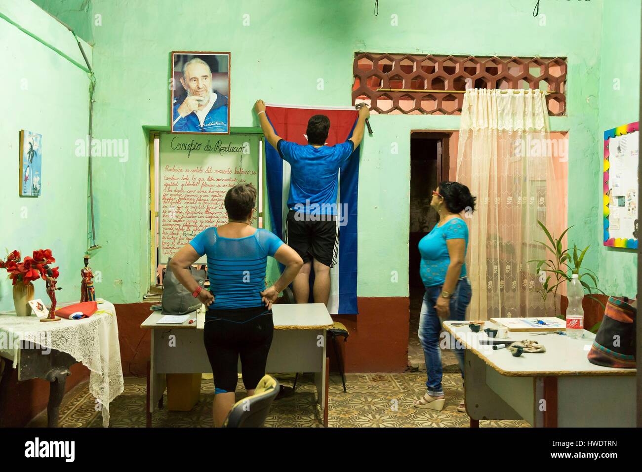 Kuba, Provinz Sancti Spiritus, Trinidad de Cuba, historischen Zentrum als Weltkulturerbe von der UNESCO, Frau Auflegen eine kubanische Flagge an einer Wand in der Schule neben einem Plakat von Fidel Castro und neben den Grundlagen der Kubanischen Revolution, die von Fidel Castro wenige Tage nach Fidel Castro gestorben Stockfoto