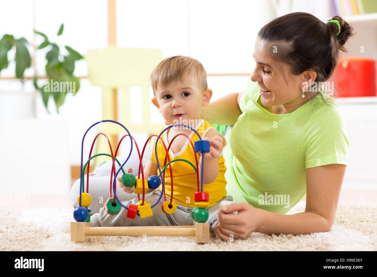 Kind Junge spielt mit Bildungs-Spielzeug im Kindergarten zu Hause. Glückliche Mutter Sohnes smart zu betrachten. Stockfoto