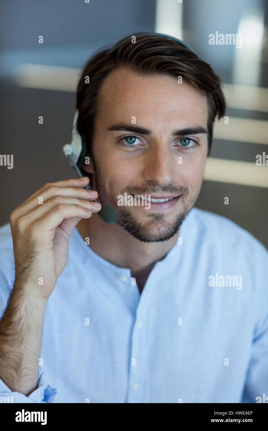 Lächelnde Kundenservice über Kopfhörer im Büro Stockfoto