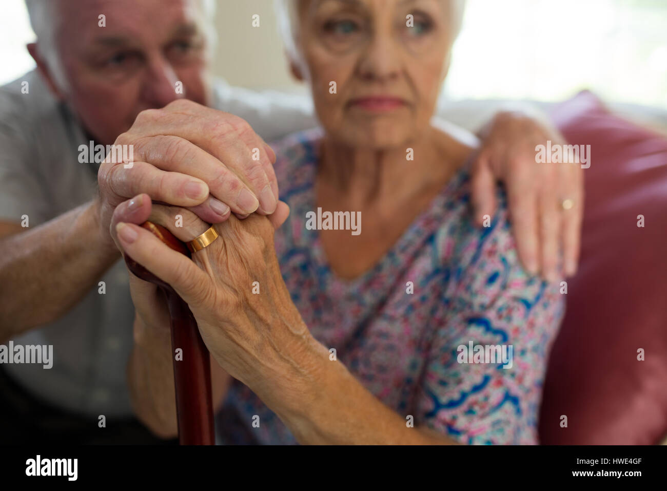 Senior Woman Hand in Hand der alten Frau mit Gehstock im Wohnzimmer zu Hause Stockfoto