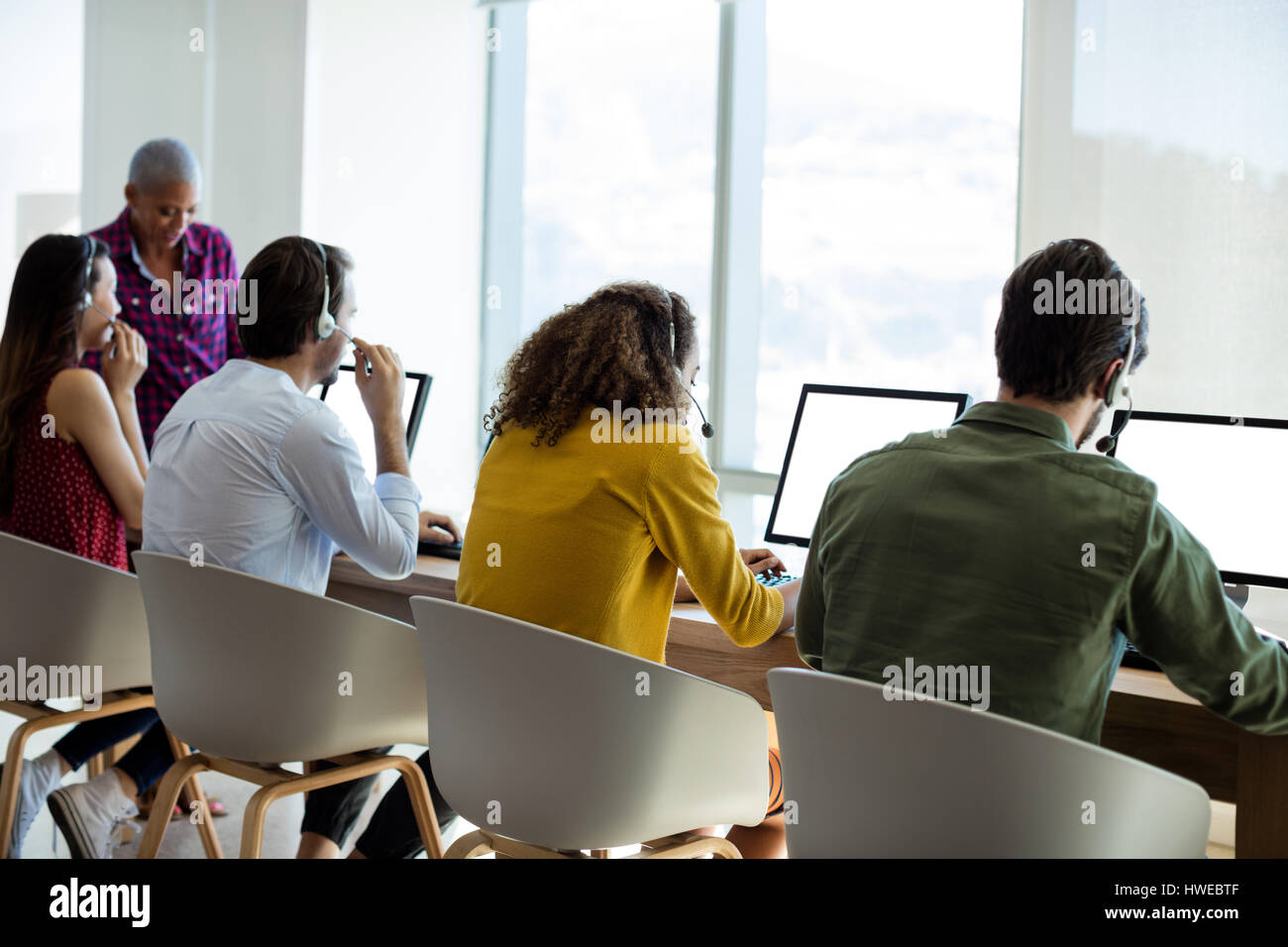 Customer Service Executive am Kopfhörer im Büro sprechen Stockfoto