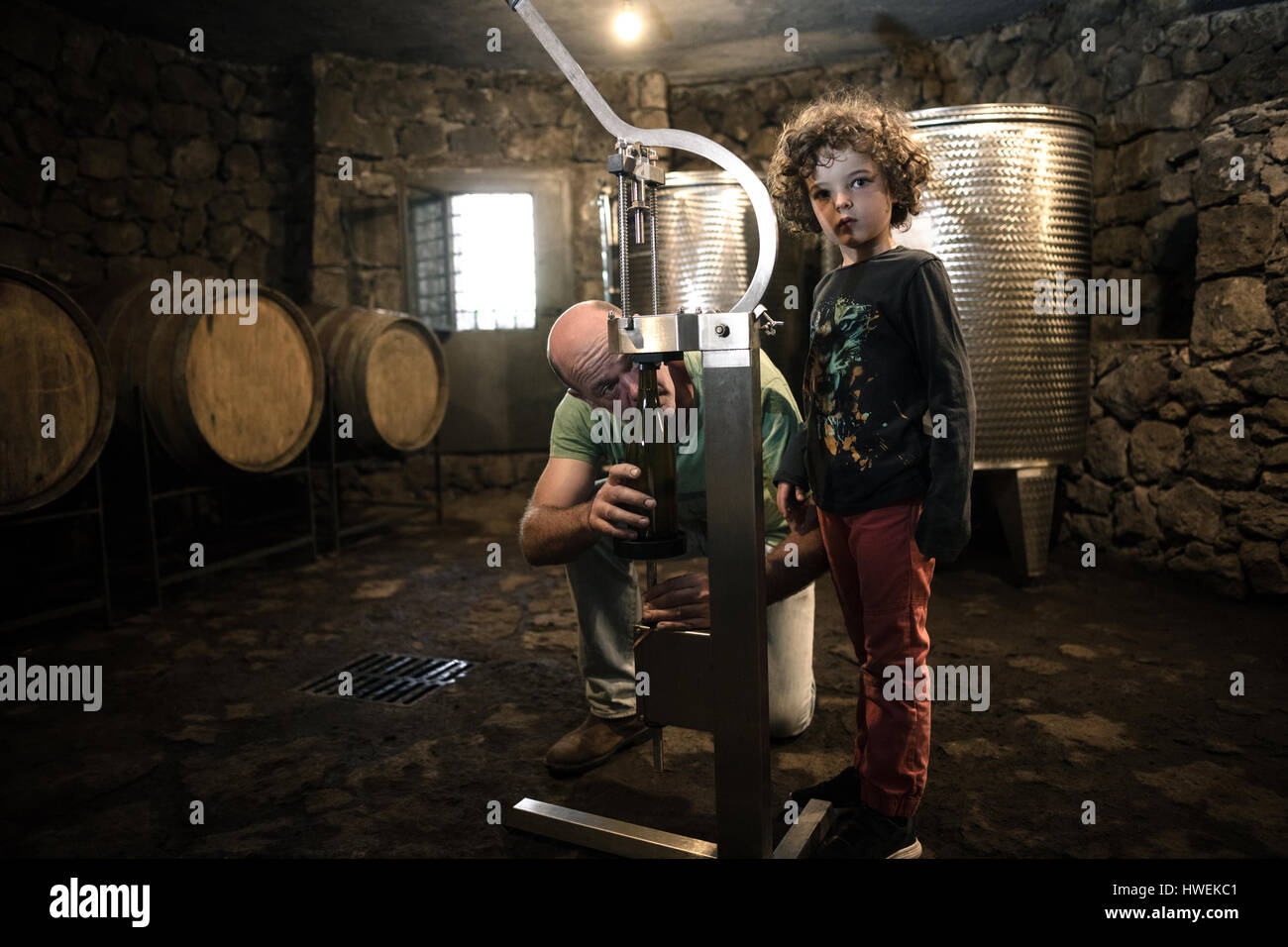 Junge mit Winzer Korken Flasche Wein im Keller Stockfoto